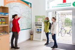 Eine Mitarbeiterin der Tourist-Information Fürstenwalde gibt Infos an einer Karte im Eingangsbereich