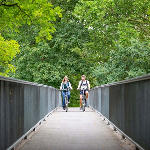 Zwei Fahrradfahrer radeln über die Pintschbrücke in Fürstenwalde